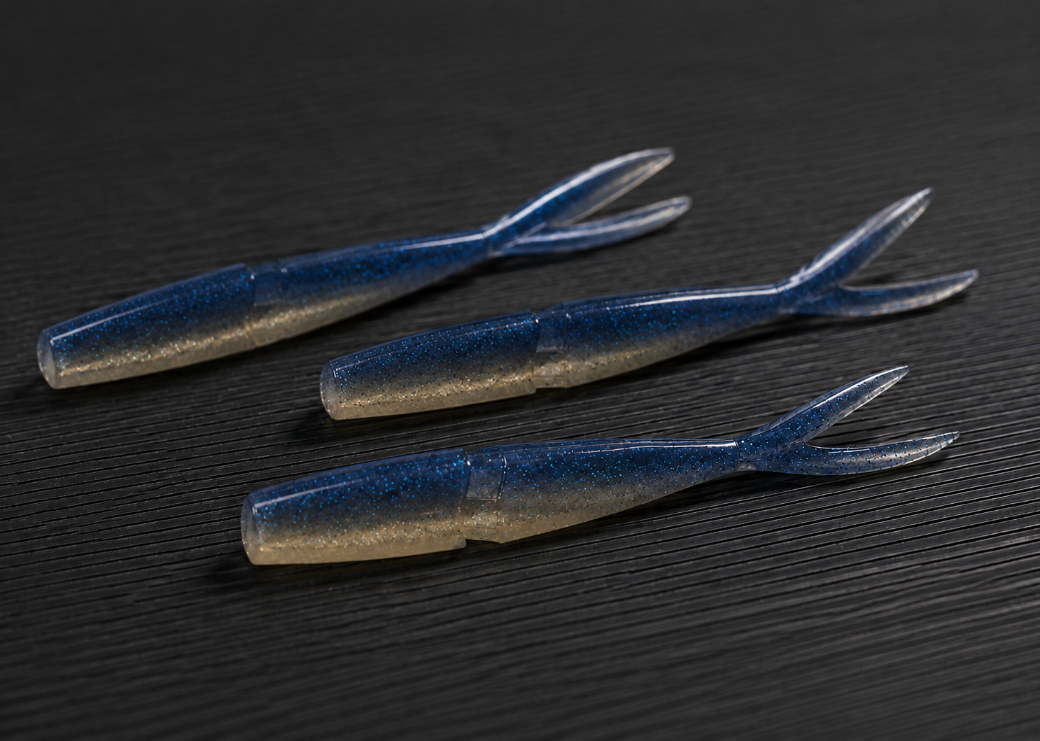SaltVector Jerkshad soft plastic lures on a dark textured surface